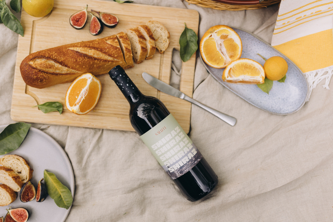 Top View of Baguette, Wine, and Oranges on a Picnic